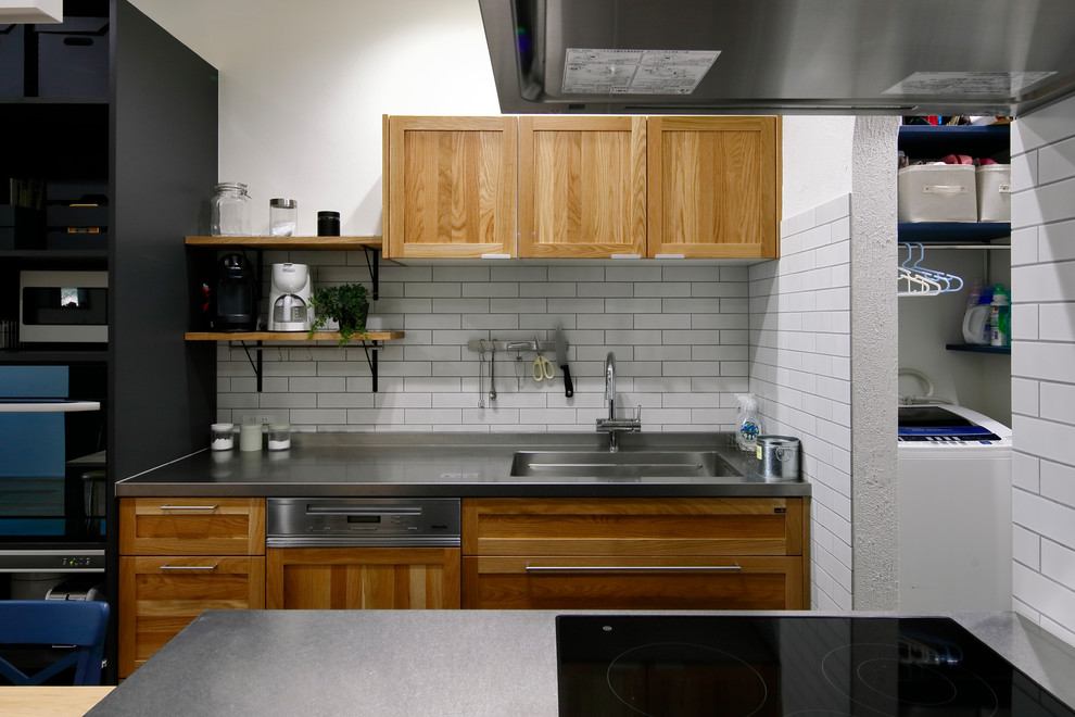 Example of a danish galley open concept kitchen design in Other with a single-bowl sink, recessed-panel cabinets, medium tone wood cabinets, stainless steel countertops and a peninsula