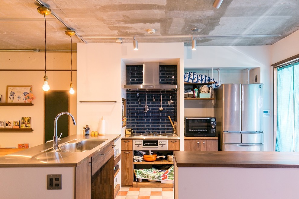 名古屋にあるアジアンスタイルのおしゃれなキッチン (シングルシンク、フラットパネル扉のキャビネット、中間色木目調キャビネット、ステンレスカウンター、マルチカラーの床) の写真