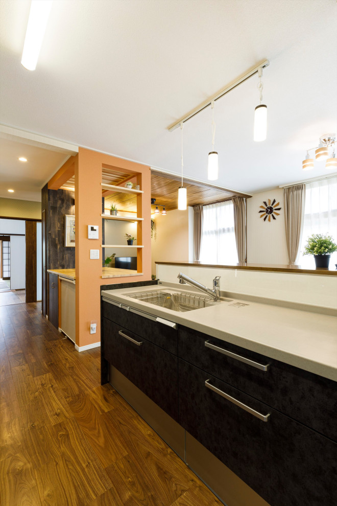 Exempel på ett asiatiskt beige linjärt beige kök med öppen planlösning, med en undermonterad diskho, släta luckor, bruna skåp, bänkskiva i koppar, vitt stänkskydd, stänkskydd i skiffer, plywoodgolv, en halv köksö och brunt golv