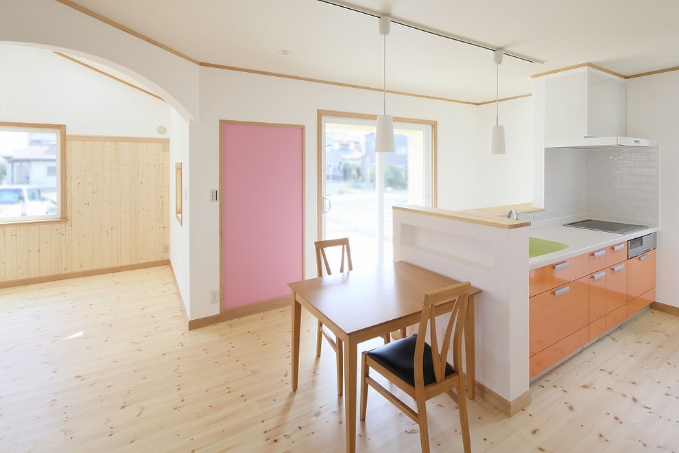 Imagen de cocina campestre de tamaño medio abierta con puertas de armario naranjas y suelo de madera clara