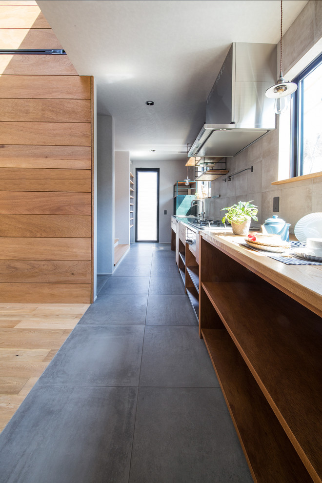 Photo of an urban single-wall open plan kitchen in Other with an integrated sink, open cabinets, medium wood cabinets, stainless steel worktops, porcelain splashback, stainless steel appliances, porcelain flooring, grey splashback and grey floors.