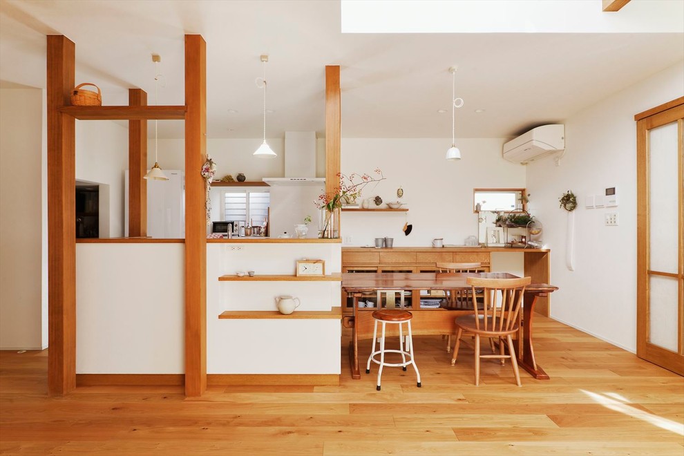 Example of an asian galley medium tone wood floor and brown floor eat-in kitchen design with medium tone wood cabinets, wood countertops, white backsplash, a peninsula and brown countertops