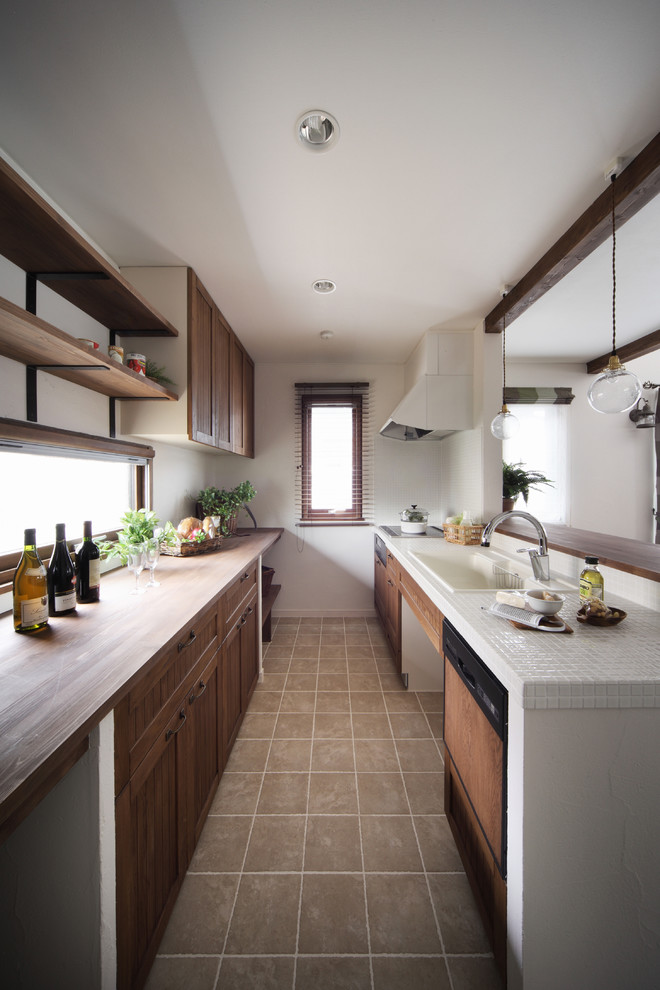 Photo of a contemporary galley kitchen in Other with a built-in sink, recessed-panel cabinets, dark wood cabinets, tile countertops and white appliances.