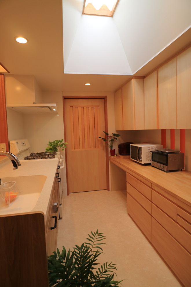 他の地域にあるアジアンスタイルのおしゃれなキッチン (一体型シンク、ベージュの床) の写真