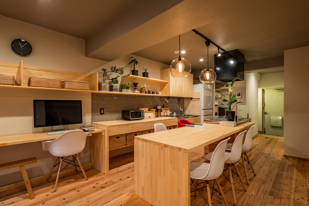 東京23区にあるアジアンスタイルのおしゃれなキッチン (シングルシンク、フラットパネル扉のキャビネット、淡色木目調キャビネット、ステンレスカウンター、無垢フローリング、茶色い床、茶色いキッチンカウンター) の写真