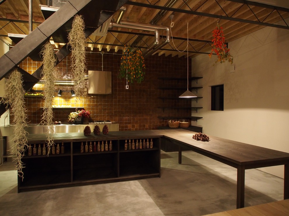 На фото: угловая кухня-гостиная в стиле лофт с открытыми фасадами, темными деревянными фасадами, деревянной столешницей, коричневым фартуком, техникой из нержавеющей стали, бетонным полом и островом