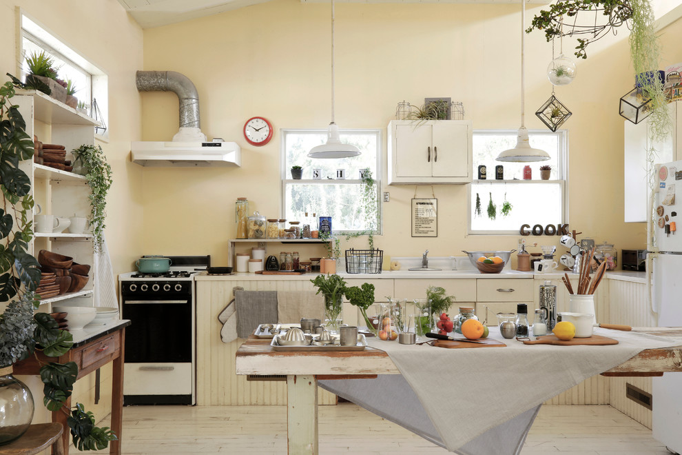 Eklektische Küche ohne Insel in L-Form mit flächenbündigen Schrankfronten, weißen Schränken, Küchenrückwand in Weiß und gebeiztem Holzboden in Sonstige