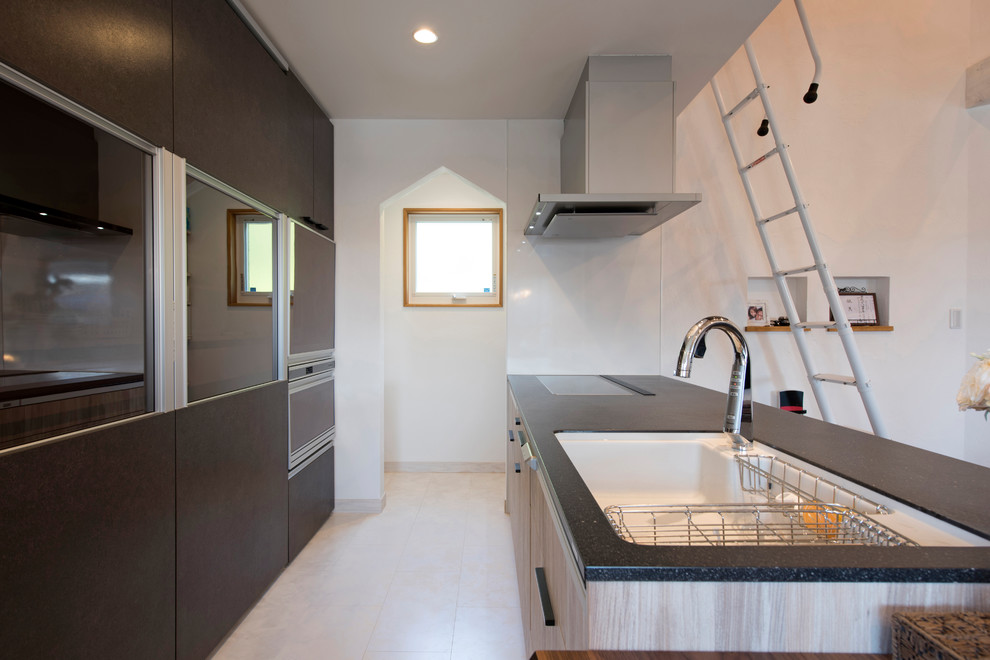 他の地域にあるコンテンポラリースタイルのおしゃれなキッチン (シングルシンク、フラットパネル扉のキャビネット、白い床) の写真