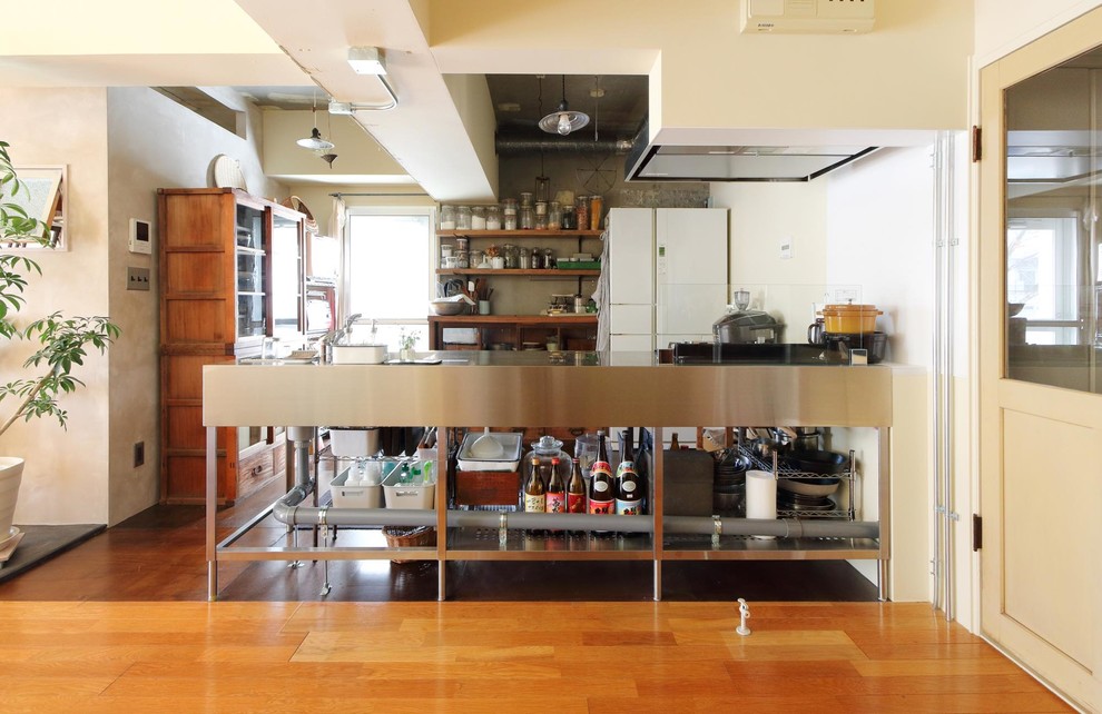 東京23区にあるインダストリアルスタイルのおしゃれなキッチン (シングルシンク、オープンシェルフ、ステンレスキャビネット、ステンレスカウンター、濃色無垢フローリング、茶色い床) の写真
