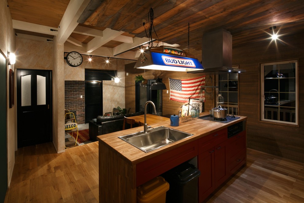 Foto de cocina lineal industrial abierta con fregadero encastrado, armarios estilo shaker, puertas de armario de madera oscura, encimera de madera, suelo de madera en tonos medios y una isla