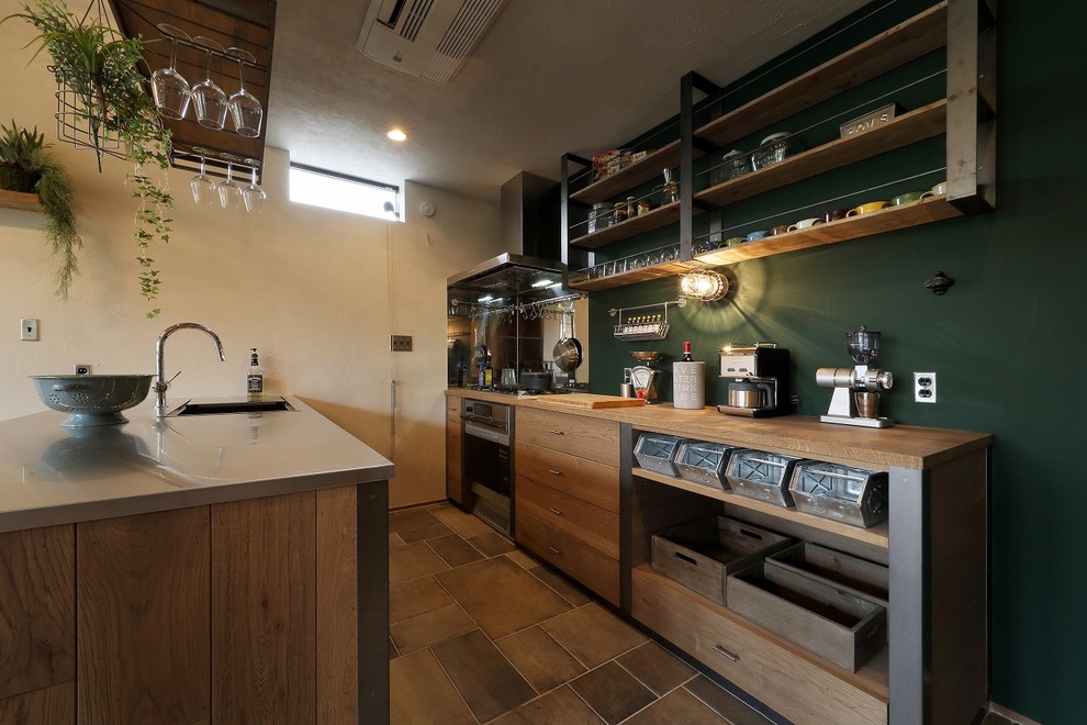 Bild på ett industriellt brun brunt kök, med en enkel diskho, öppna hyllor, skåp i slitet trä, bänkskiva i rostfritt stål, en halv köksö och brunt golv