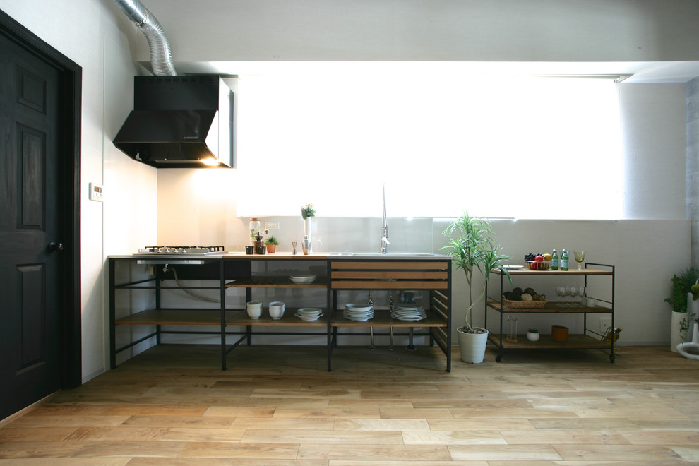 Idee per una cucina lineare industriale con lavello integrato, parquet chiaro e pavimento beige