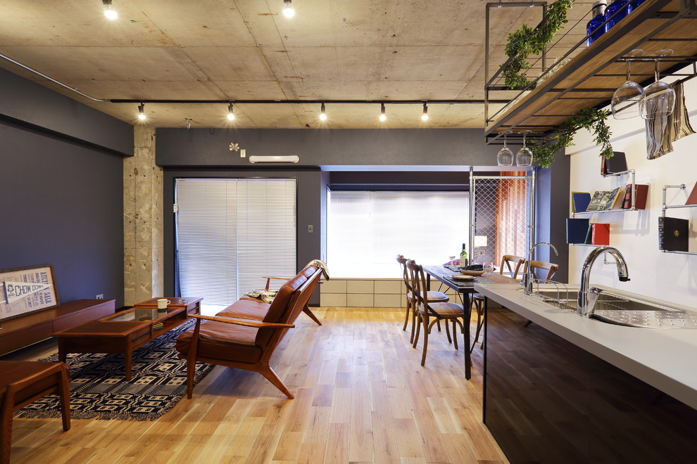 This is an example of a large industrial single-wall open plan kitchen in Tokyo with composite countertops, coloured appliances, medium hardwood flooring and a breakfast bar.