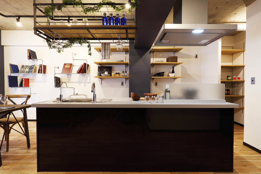 Imagen de cocina lineal urbana grande abierta con encimera de acrílico, electrodomésticos de colores, suelo de madera en tonos medios y península