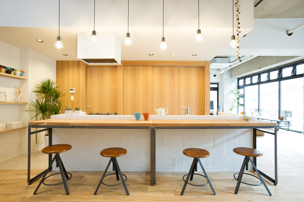 Свежая идея для дизайна: прямая кухня-гостиная в стиле лофт с фасадами цвета дерева среднего тона, деревянной столешницей, светлым паркетным полом, островом и бежевым полом - отличное фото интерьера