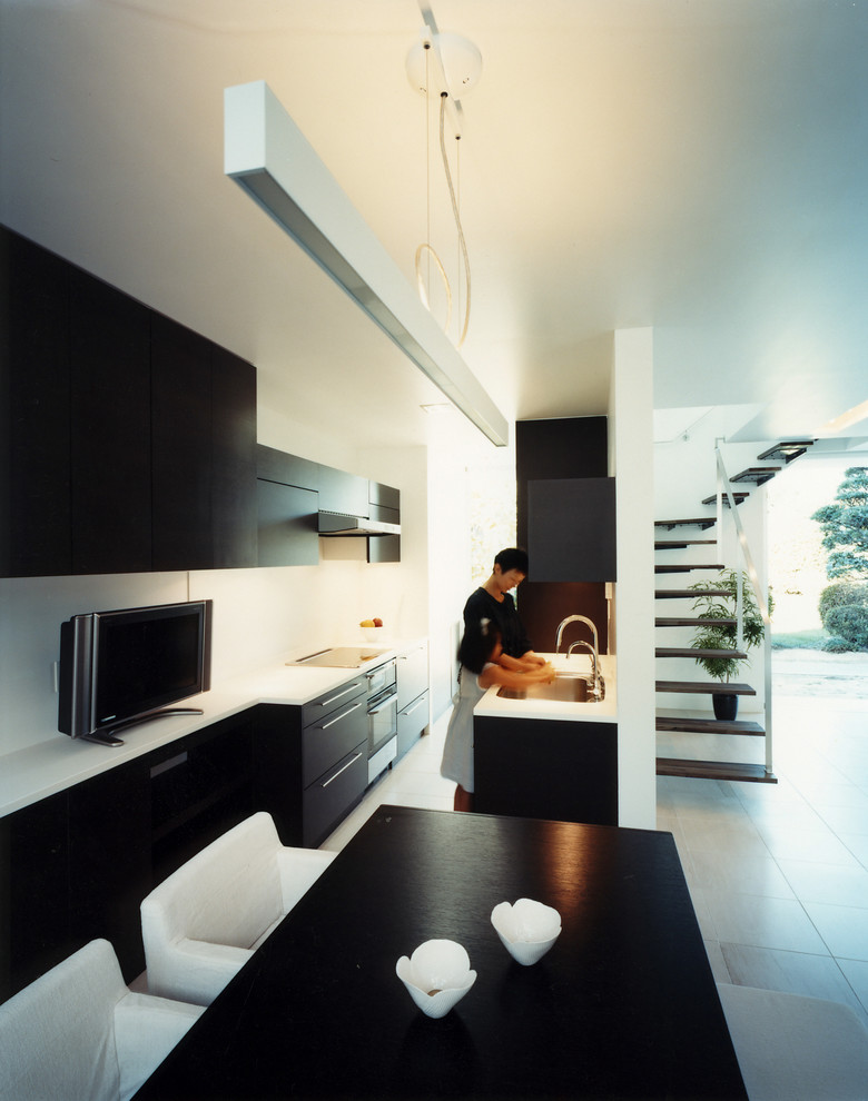 Стильный дизайн: параллельная кухня в восточном стиле с столешницей из акрилового камня и полом из известняка - последний тренд