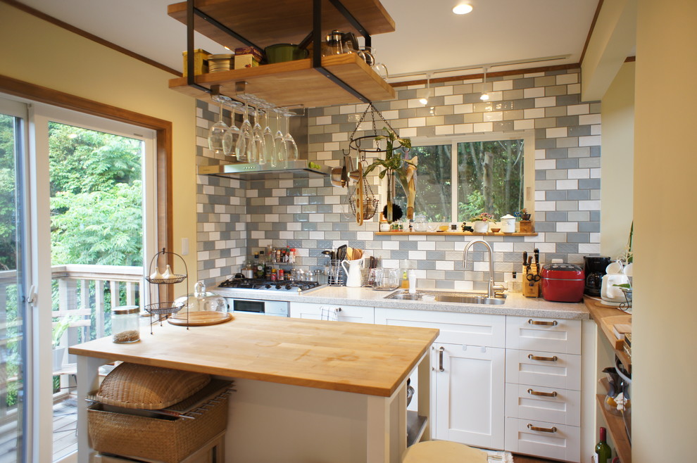 Kleine Stilmix Küche mit Waschbecken, Schrankfronten mit vertiefter Füllung, weißen Schränken und braunem Holzboden in Sonstige