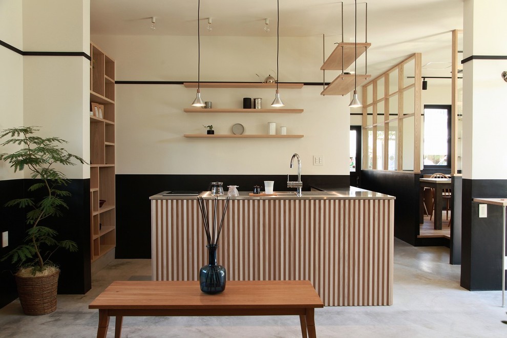 Свежая идея для дизайна: кухня в восточном стиле с одинарной мойкой, столешницей из нержавеющей стали, бетонным полом, островом и серым полом - отличное фото интерьера