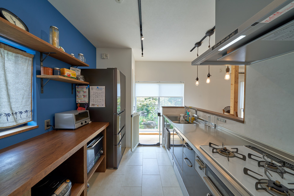 Cette image montre une cuisine linéaire rustique avec un évier 1 bac, un placard à porte plane, une péninsule et un sol blanc.