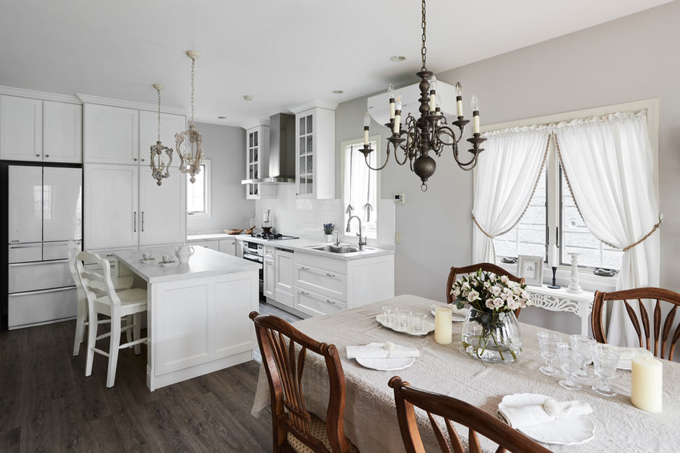 Bild på ett shabby chic-inspirerat grå grått kök, med en undermonterad diskho, skåp i shakerstil, vita skåp, bänkskiva i koppar, rostfria vitvaror, en köksö och grått golv