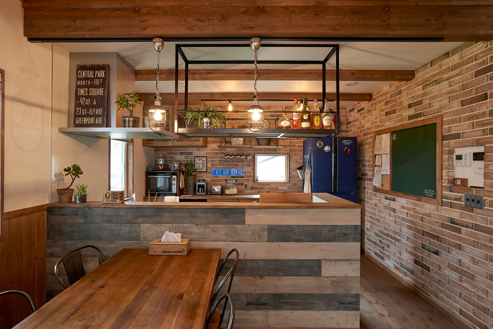 Esempio di una cucina abitabile country con pavimento in legno massello medio e pavimento marrone