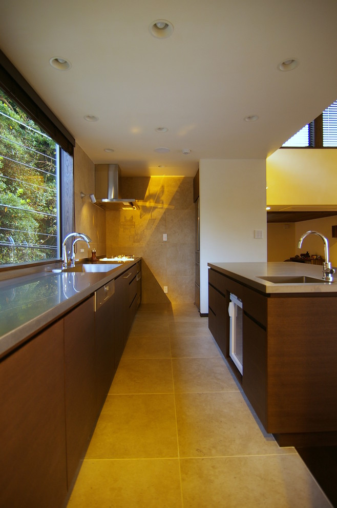 Immagine di una cucina minimalista con lavello integrato, ante lisce, ante in legno scuro, top in acciaio inossidabile e pavimento beige