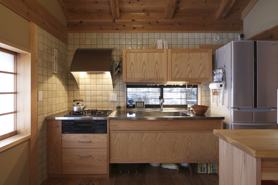 Idées déco pour une cuisine ouverte linéaire avec un plan de travail en inox et un sol en bois brun.