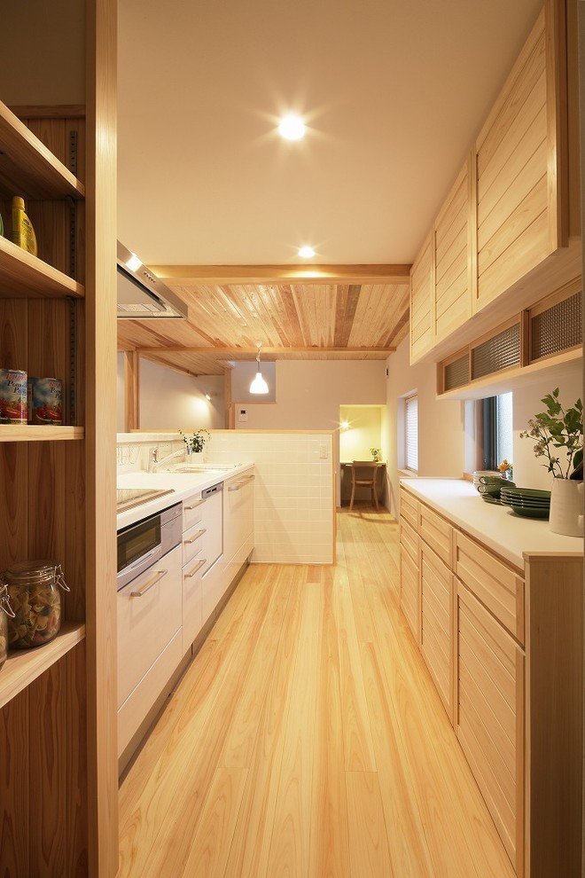 Источник вдохновения для домашнего уюта: параллельная кухня-гостиная в стиле кантри с светлыми деревянными фасадами, столешницей из акрилового камня, белым фартуком, фартуком из плитки мозаики и белой столешницей