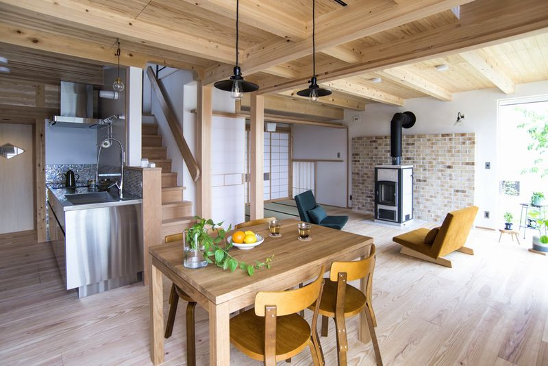 Diseño de cocina lineal moderna con suelo de madera en tonos medios, puertas de armario en acero inoxidable, encimera de acero inoxidable y vigas vistas