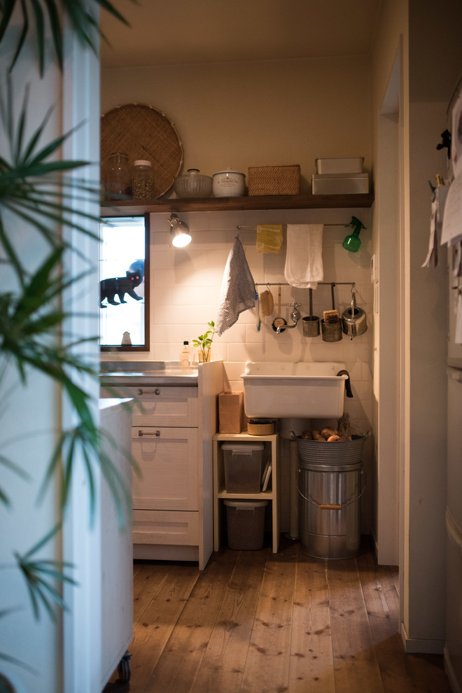 Foto di una cucina con top in acciaio inossidabile, paraspruzzi bianco, paraspruzzi in gres porcellanato e parquet scuro