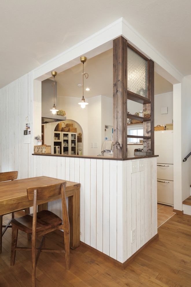 На фото: кухня-гостиная среднего размера в стиле кантри с полом из терракотовой плитки и бежевым полом