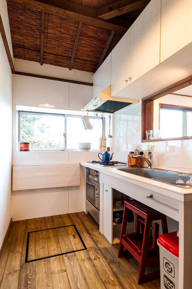 Rustikale Küche mit Waschbecken, braunem Holzboden und braunem Boden in Sonstige