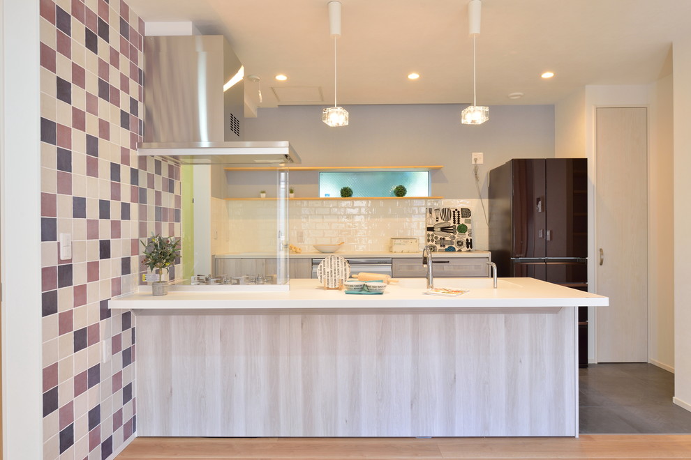 Modelo de cocina lineal actual con fregadero bajoencimera, armarios con paneles lisos, salpicadero blanco, salpicadero de azulejos tipo metro y electrodomésticos de acero inoxidable
