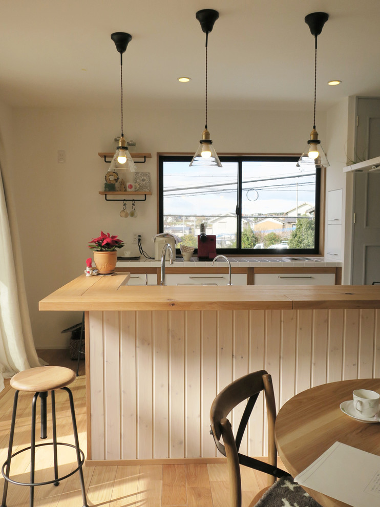 На фото: прямая кухня-гостиная с столешницей из акрилового камня, фартуком из керамогранитной плитки, паркетным полом среднего тона и полуостровом с
