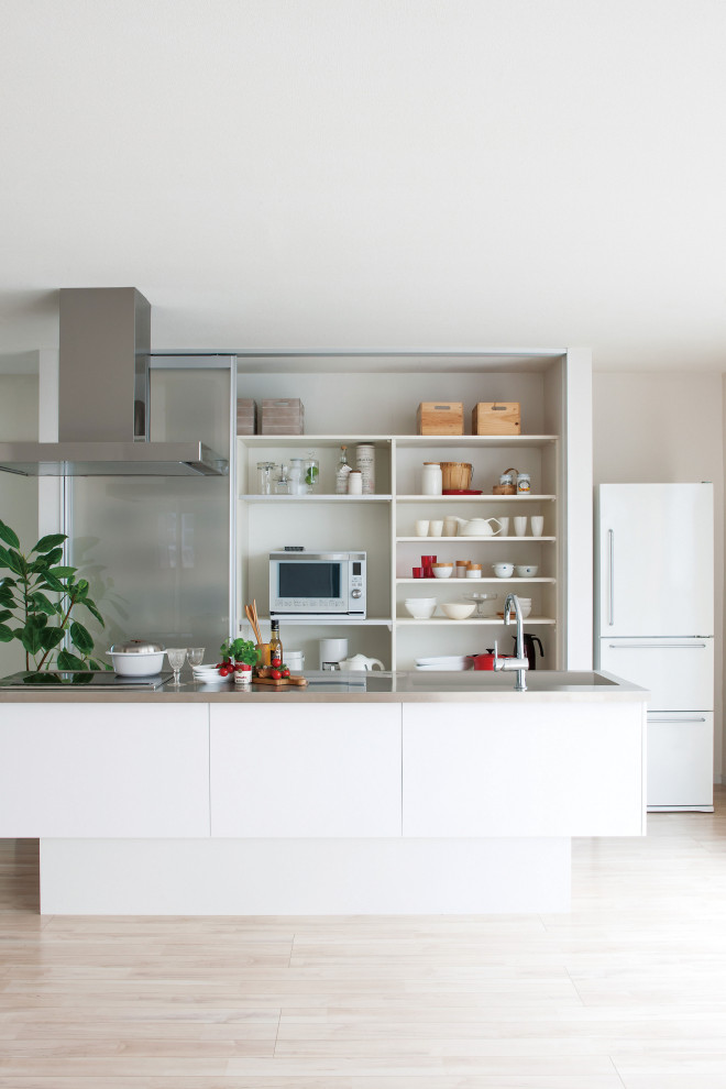Ispirazione per una cucina minimal di medie dimensioni con lavello integrato, ante lisce, ante bianche, pavimento beige e top grigio