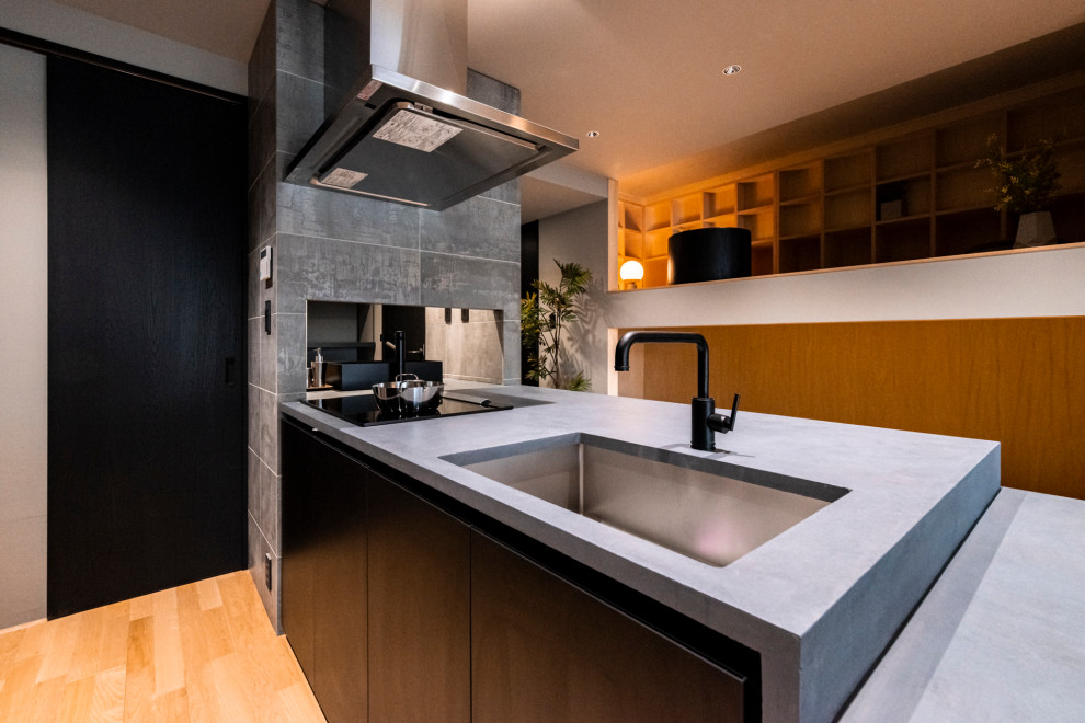 Immagine di una piccola cucina etnica con lavello integrato, paraspruzzi grigio, pavimento marrone e top grigio
