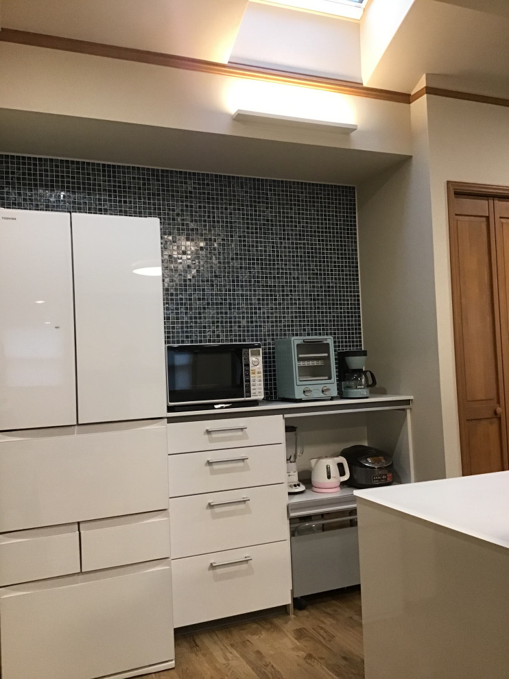 京都にある中くらいなトラディショナルスタイルのおしゃれなキッチン (アンダーカウンターシンク、フラットパネル扉のキャビネット、白いキャビネット、ガラスカウンター、白いキッチンパネル、ガラス板のキッチンパネル、シルバーの調理設備、無垢フローリング、アイランドなし、茶色い床、白いキッチンカウンター、クロスの天井) の写真