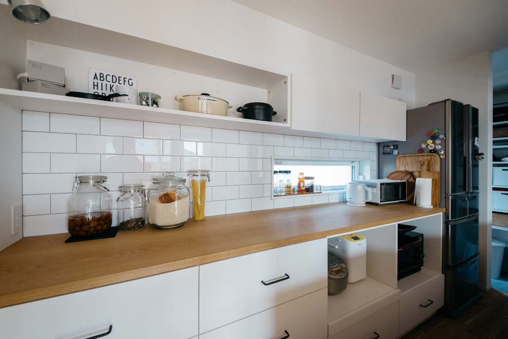 Idéer för ett modernt kök, med vita skåp och träbänkskiva
