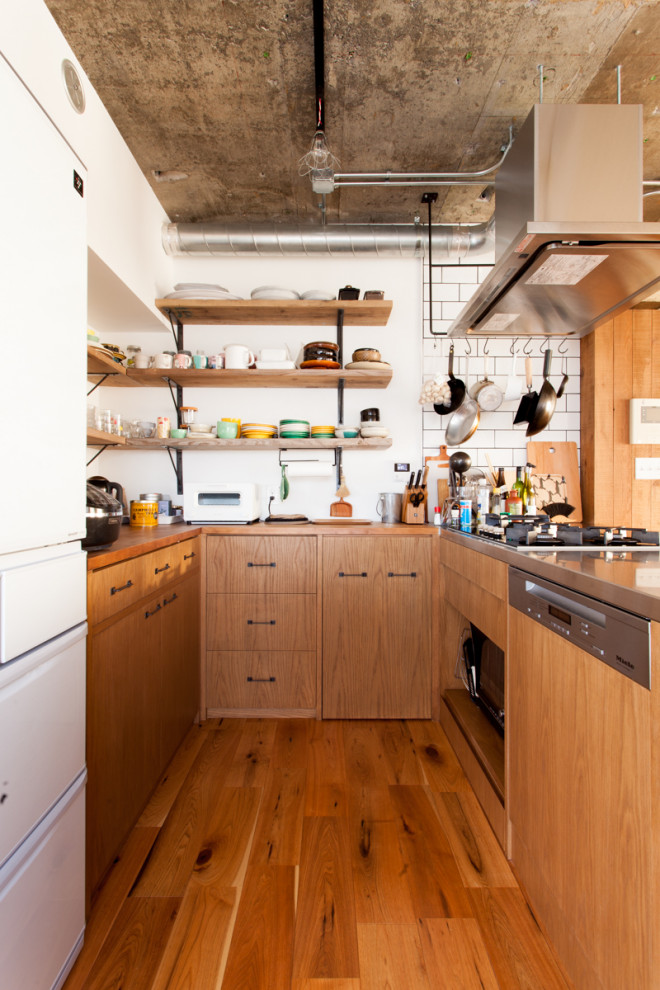 U-shaped medium tone wood floor and brown floor kitchen photo in Tokyo with flat-panel cabinets, medium tone wood cabinets, wood countertops, a peninsula and brown countertops
