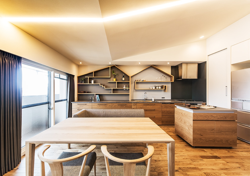 Moderne Wohnküche in L-Form mit Einbauwaschbecken, flächenbündigen Schrankfronten, hellbraunen Holzschränken, braunem Holzboden, Kücheninsel, braunem Boden und grauer Arbeitsplatte in Kobe