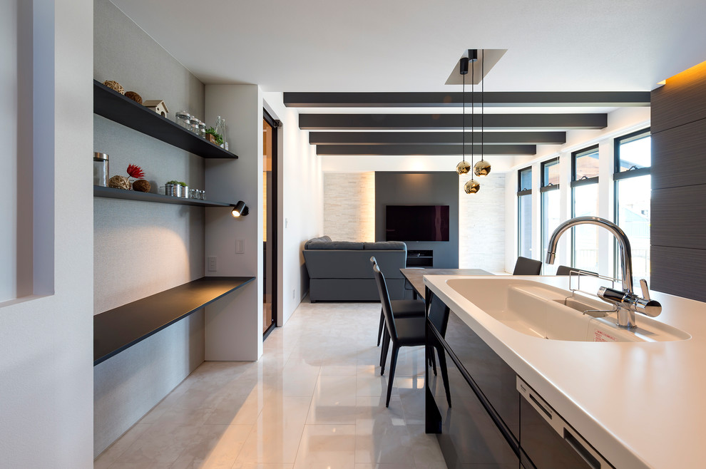 Modelo de cocina minimalista abierta con fregadero integrado, armarios con paneles lisos, puertas de armario negras, suelo de mármol y suelo blanco