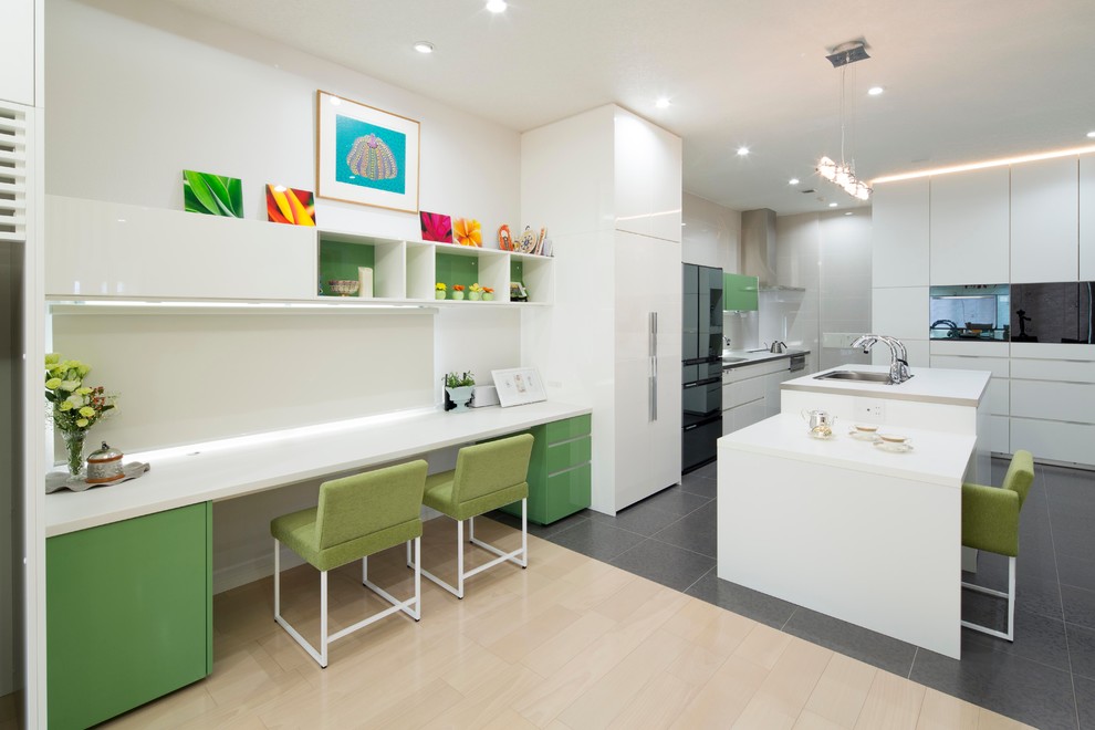 Modelo de cocina lineal contemporánea abierta con armarios con paneles lisos, puertas de armario blancas, electrodomésticos negros y una isla