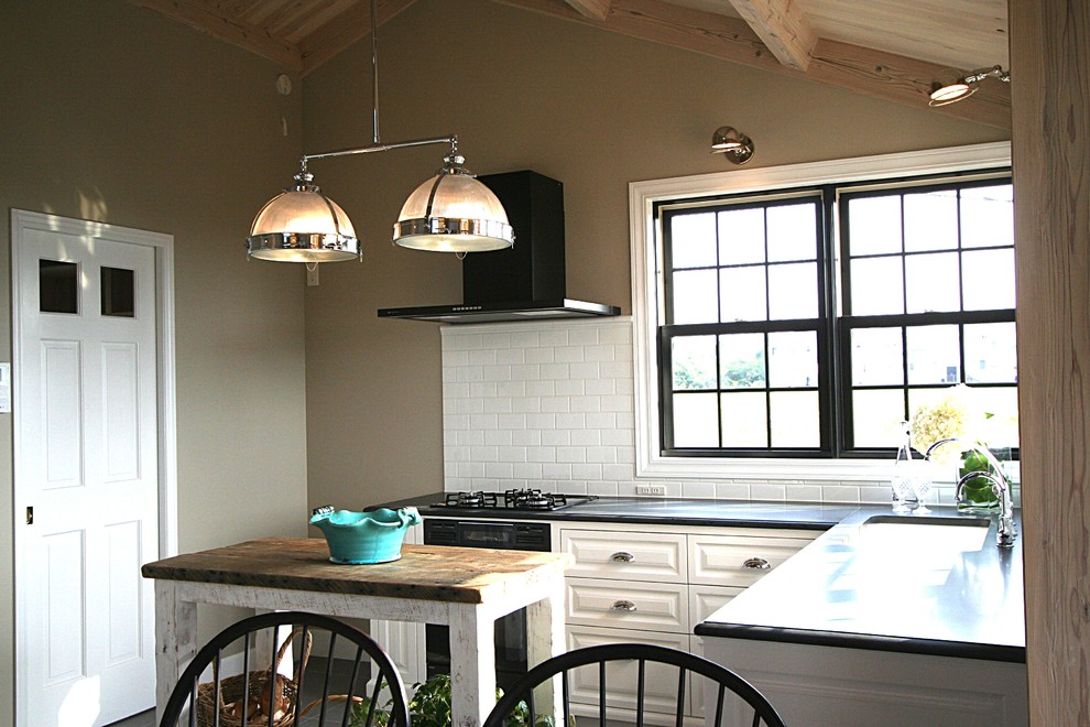 Klassische Küche mit Küchenrückwand in Weiß und Rückwand aus Metrofliesen in Sonstige