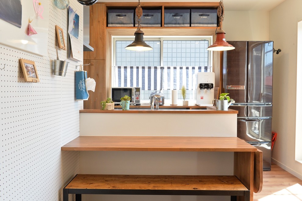 他の地域にあるインダストリアルスタイルのおしゃれなキッチン (淡色無垢フローリング、茶色い床) の写真