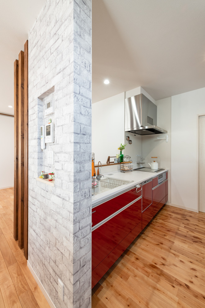 Immagine di una cucina minimalista con ante rosse, pavimento beige e top bianco