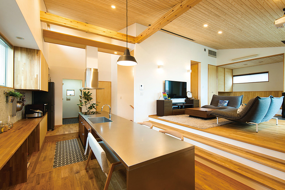 Aménagement d'une cuisine ouverte contemporaine avec un sol en bois brun.