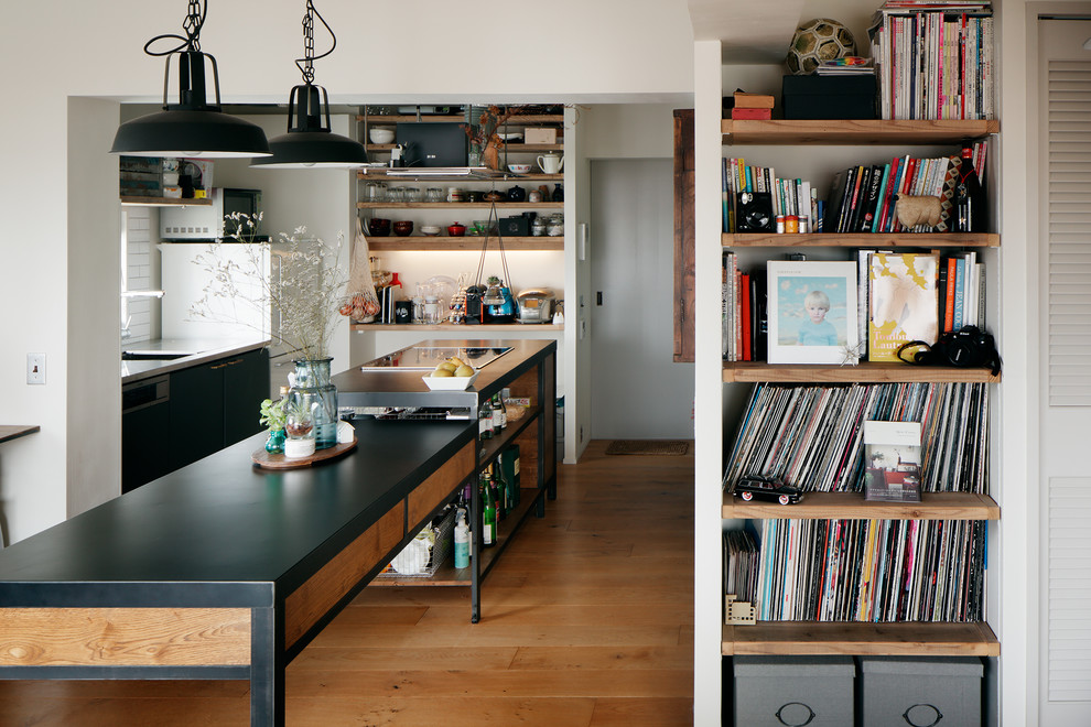 Inspiration for an urban galley kitchen in Other with a single-bowl sink, medium hardwood flooring, an island and brown floors.