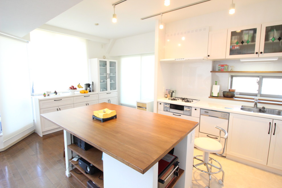 横浜にある北欧スタイルのおしゃれなキッチン (シングルシンク、落し込みパネル扉のキャビネット、白いキャビネット、白いキッチンパネル、茶色い床) の写真