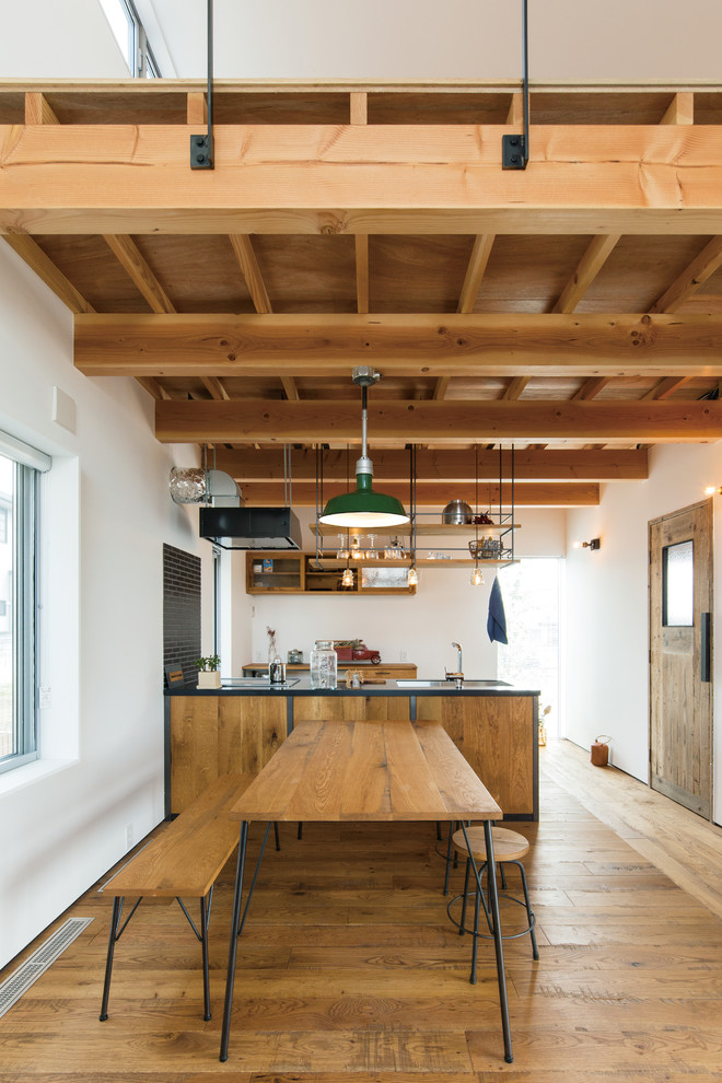 Industrial Wohnküche mit dunklem Holzboden und braunem Boden in Sonstige