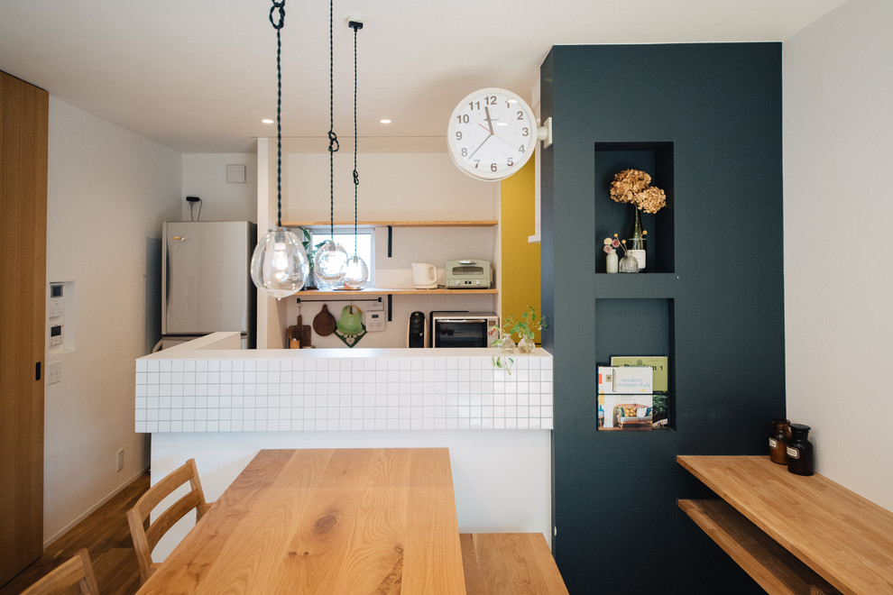 На фото: маленькая параллельная кухня-гостиная в скандинавском стиле с паркетным полом среднего тона, полуостровом и коричневым полом для на участке и в саду